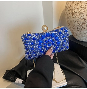 Détail d'une pochette de soirée bleu foncé avec strass, fermoir perle et chaîne
