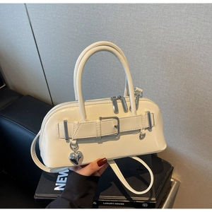 Détail d'un sac bowling blanc brillant avec pendentif coeur et garniture argentée