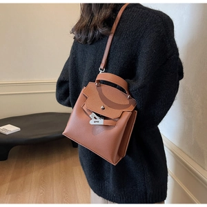 Detailansicht der karamellbraunen Lederhandtasche mit Silberverschluss am Model