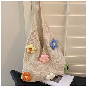 Detailed knit texture of beige floral tote bag with colorful 3D knitted flowers