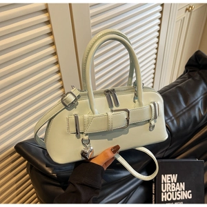 Détail du sac à main en cuir vert menthe avec boucle en métal argenté et pendentif cœur