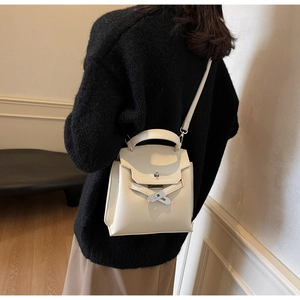 Detailansicht der weißen Ledertextur und der silbernen Schließe an der Kelly Handtasche