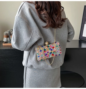 Gros plan de strass colorés et motifs de fleurs en gemmes sur une pochette de soirée