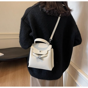 Detailansicht der cremeweißen Lederhandtasche mit klassischem silbernem Drehverschluss