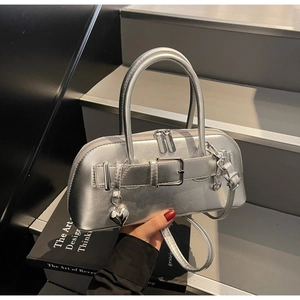 Détail du sac à main argenté avec breloque cœur et boucle décorative argentée