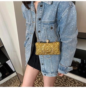 Détails d'une pochette de luxe dorée ornée de strass et de cristaux en forme de fleur