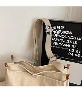 Detail of wide adjustable textile shoulder strap on minimalist beige canvas crossbody bag