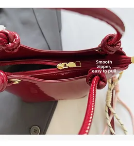 Primer plano detallado de la cremallera dorada suave del bolso de charol rojo brillante