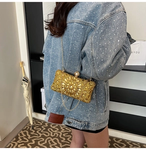 Vue détaillée de la pochette de soirée dorée de luxe avec strass et fermoir perle
