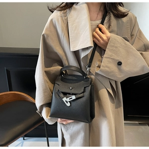 Detailansicht der kleinen schwarzen Lederhandtasche mit Litschimuster und Silberverschluss