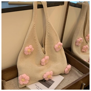 Detailed macro view of beige crochet tote bag featuring pink 3D flower knits