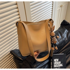 Détail du sac seau en cuir kaki avec logo et charmant lapin en peluche attaché