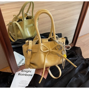 Gelbe Falten-Eimertasche mit Schleife und silbernen Perlenanhänger im Detail