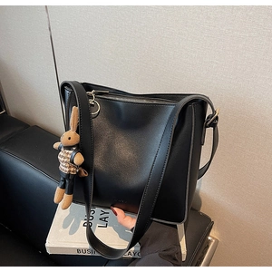 Gros plan d'un sac cabas noir minimaliste avec texture cuir et charmant pendentif lapin