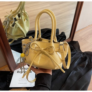 Detail der gerafften Ledertasche mit großer Schleife und silberner Perlenkette