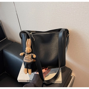 Détail du sac cabas en similicuir noir mat avec un pendentif lapin en pied-de-poule