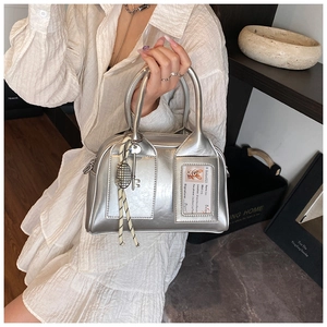 Close-up of a silver shiny bowling bag with transparent card slot and key pendant detail