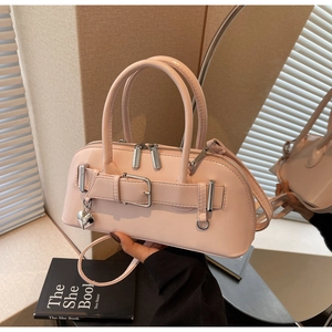 Vue détaillée du sac bowling rose avec pendentif cœur sur une surface réfléchissante