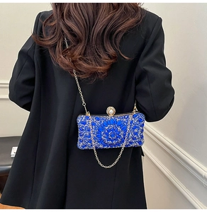 Détail du sac de soirée perlé bleu avec motif floral en cristal et chaîne dorée