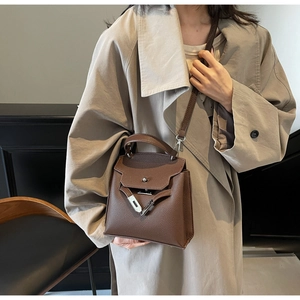 Nahaufnahme der braunen Lederhandtasche mit Lychee-Muster und silbernem Drehverschluss