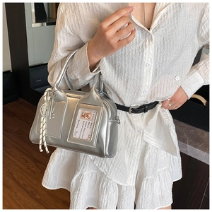 Detail of silver metallic Boston bag with clear card slot and dog pattern decoration