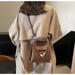 Braune Handtasche mit Litschimuster zum beigen Mantel für einen eleganten Vintage-Look