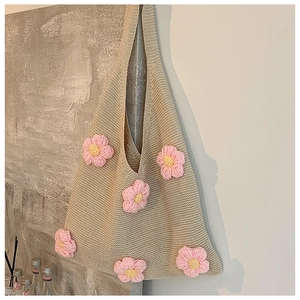 Detailed close-up of handmade knit tote bag with 3D crochet flowers and thick yarn texture