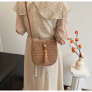 Borsa a tracolla in paglia alla moda con nappe in perline di legno e tracolla in pelle