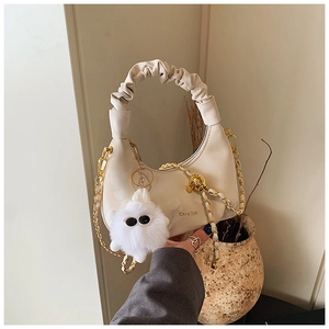 Détail du sac à main froncé blanc crème avec chaîne dorée et breloque en peluche