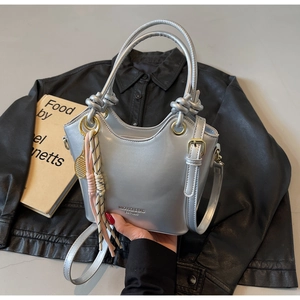 Detalle de bolso cubo en cuero encerado plateado con asa de nudo y acabado metalizado
