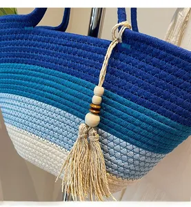 Détail d'un sac de plage tressé avec dégradé bleu et pompon décoratif de style bohème
