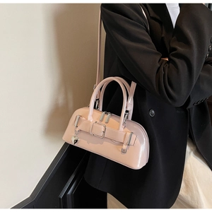 Détail du sac à main en cuir verni rose avec pendentif cœur et boucle décorative