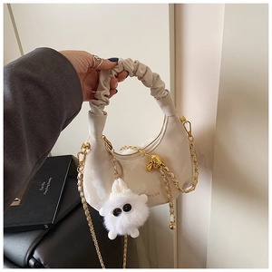 Détail du sac demi-lune blanc cassé avec poignée plissée chaîne dorée et peluche