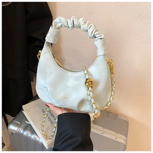 Détail de la poignée froncée vert menthe et chaîne dorée avec breloque boule sur le sac