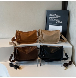 Retro faux leather shoulder bags in four colors with tassel details on a display stand