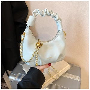 Détail du sac hobo plissé bleu clair avec nœud doré et bandoulière en chaîne