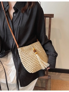 Borsa a tracolla minimalista in paglia beige con nappe di perline in legno e tracolla in pelle