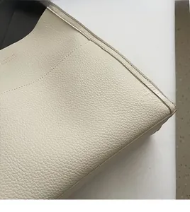 Close-up of creamy white litchi pattern leather showing fine texture and neat stitching