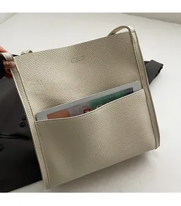 Detail of cream lychee texture tote bag featuring a large front pocket for tablets