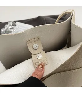 Close-up of metal magnetic buckle closure on large capacity litchi grain tote bag