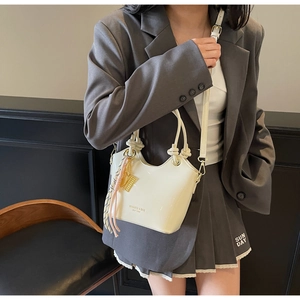 Detalle de bolso tipo cubo en cuero crema encerado con pañuelo de seda y metal dorado