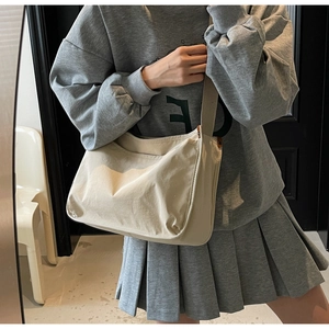 Detail of minimalist beige canvas tote bag with wide strap for casual crossbody wear
