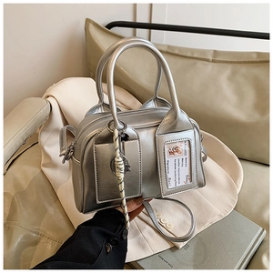 Detail of silver metallic boston bag with clear card slot and woven rope keychain pendant