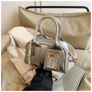 Silver boston handbag with a clear card slot and decorative woven rope charm detail