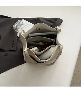Interior view of off-white tote bag showing multiple compartments and magnetic closure