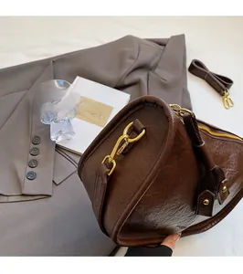 Detailed close-up of dark brown vintage pillow bag featuring textured lychee pattern leather