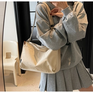 Crossbody canvas tote bag in off-white shown on model for daily casual wear