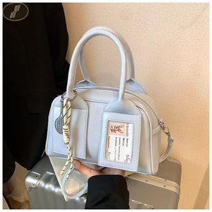 Detail of light blue mini satchel with tennis racket charm and card slot pocket