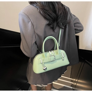 Sac bowling chic vert menthe porté avec un blazer oversize gris foncé élégant