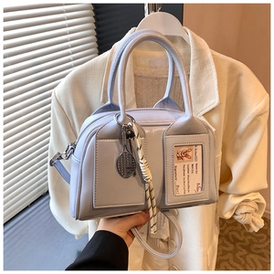 Close-up of sky blue bowling bag with silver hardware and tennis racket charm detail